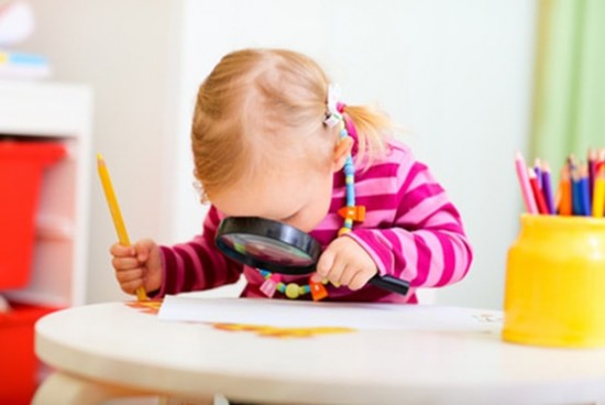 Enfant avec une loupe et un crayon